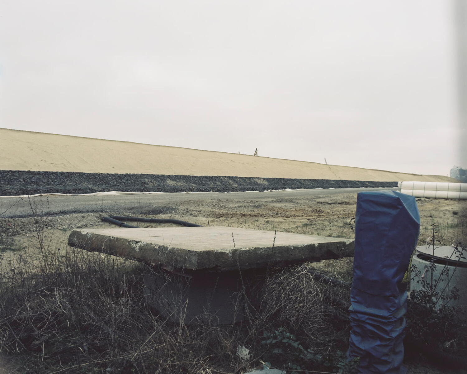 Zement und blaue Kunststoffe auf einer Baustelle.