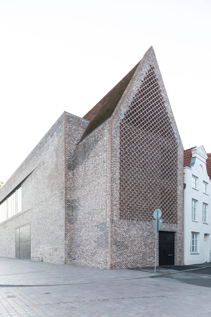 Seitenansicht der roten Backsteinfassade des Europäischen Hansemuseums von Andreas Heller Architects in Lübeck.