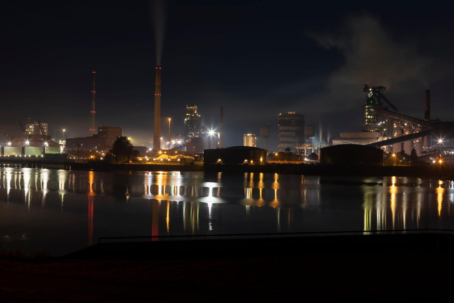 Nachtlandschaft einer Fabrik und ihrer Rauchwolken von der Serie "Night Beasts". Während der Nacht verwandeln sich diese Industrieanlagen in fantastische Kreaturen, die ein Bestiarium bilden.