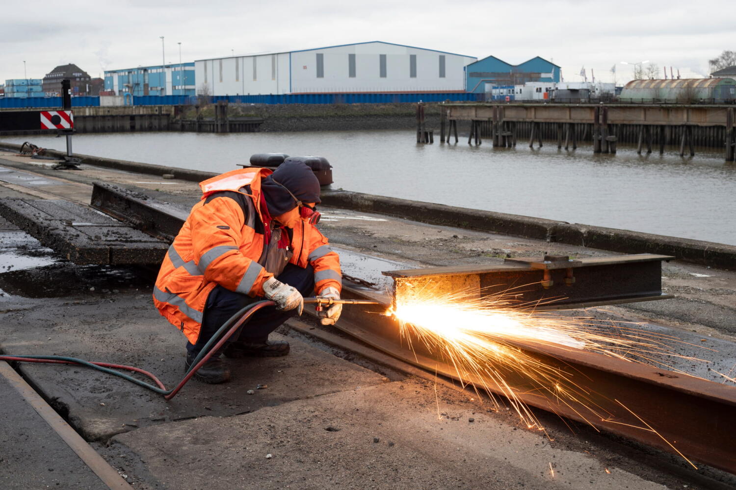 Arbeiter bei der Arbeit mit dem Schweißbrenner am Kai des Hamburger Hafens.